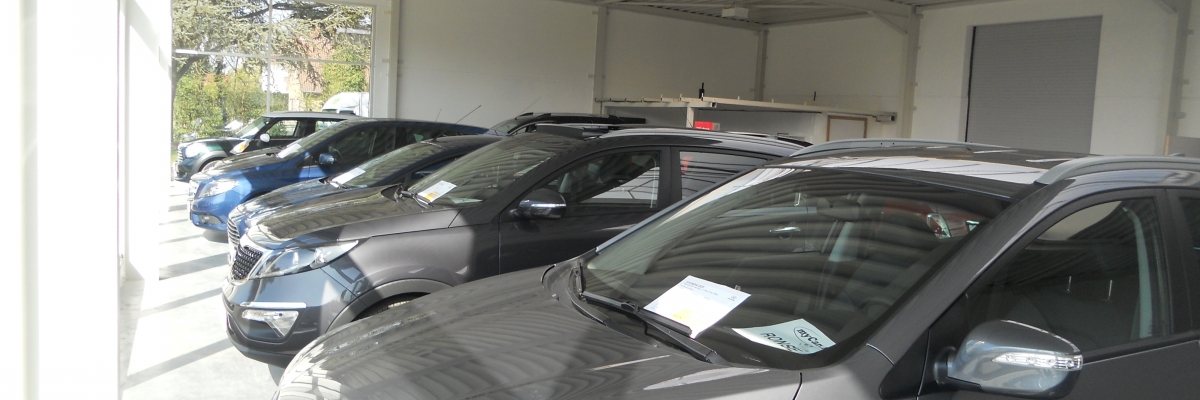 De toonzaal van Garage Vanhauwere in Ronse met jonge occasiewagens onder de luifel.